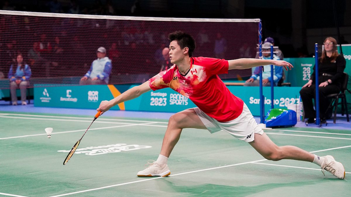 Brian Yang lunges for the birdie while wearing a red Team Canada uniform