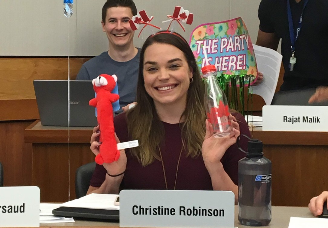Christine Robinson in a classroom smiling with a happy birthday balloon
