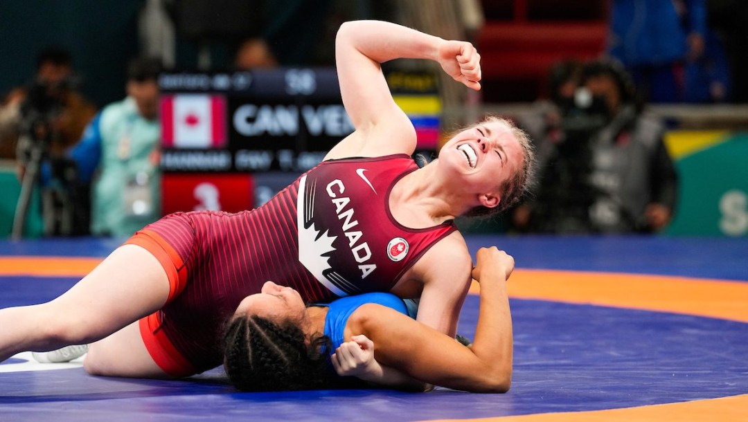 Hannah Taylor pumps her fist as she pins her opponent to the mat