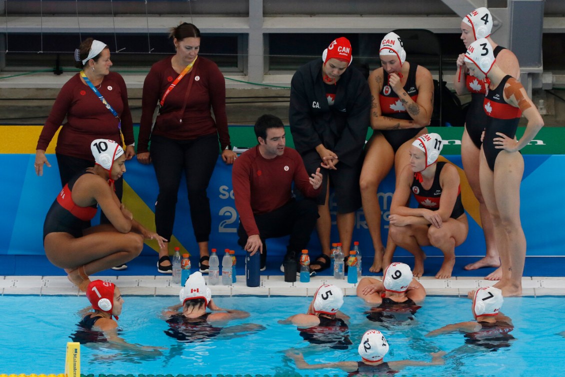 Canadian women's water polo team huddle around their coach