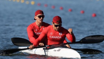 Two paddlers in a kayak, one pumps his fist