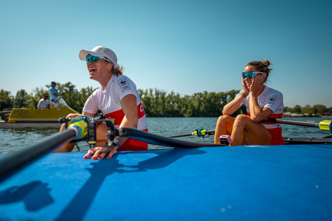 Two rowers in a boat with big smiles on their faces