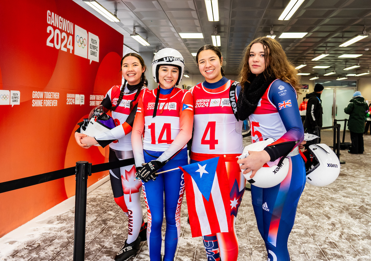 A Canadian luger poses with lugers from other countries 