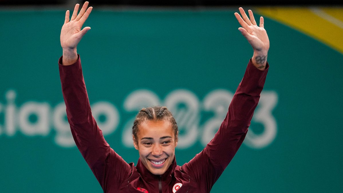 Boxer Tammara Thibeault raises her hands in victory before receiving her gold medal at the Santiago Pan American Games