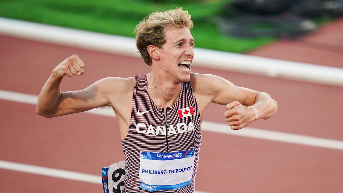 Charles Philibert-Thiboutot pumps his fist at the finish line of the men's 1500m at the Santiago Pan Am Games while wearing a red, black and white team Canada speed suit.