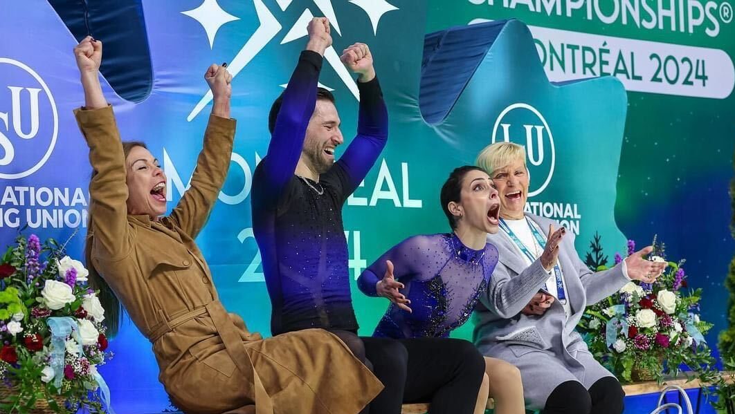 Deanna Stellato-Dudek and Maxime Deschamps in blue costumes scream and raise their arms in celebration after seeing their socre