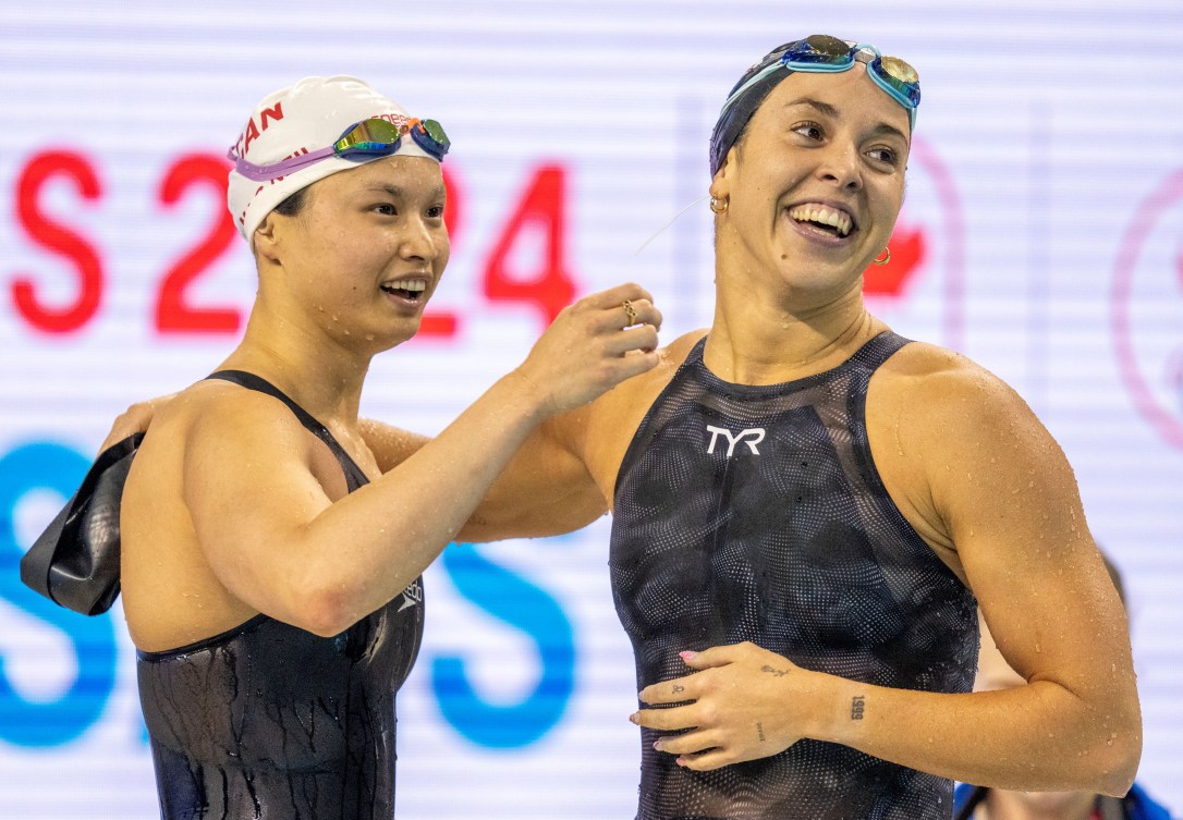 Maggie Mac Neil and Mary-Sophie Harvey move in to hug each other on the pool deck