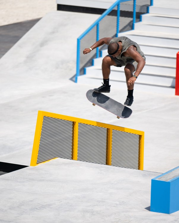 Cordano Russell hovers above a yellow railing on his skateboard