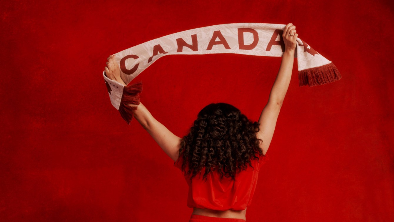 A model holds a Team Canada cheer scarf above her head