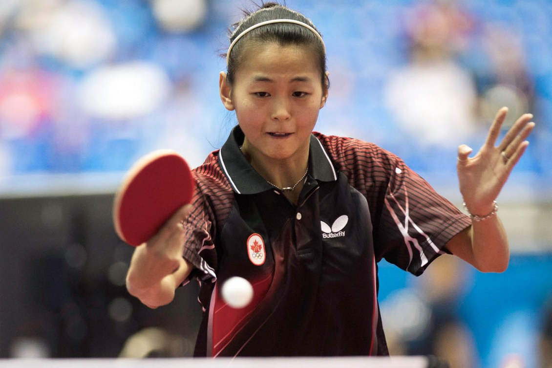Mo Zhang frappe une balle avec sa raquette.
