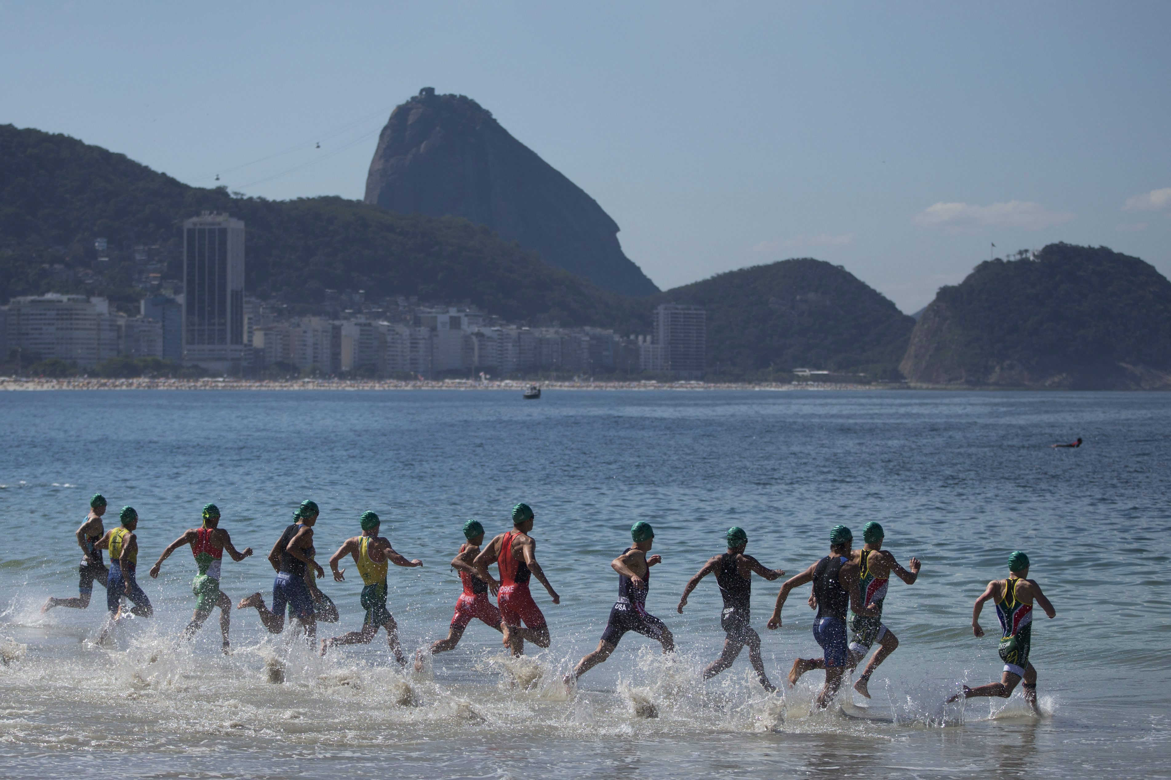 Triathletes enter the water at the start of the men's triathlon ITU World Olympic Qualification Event in Rio de Janeiro, Brazil, Sunday, Aug. 2, 2015. The World Olympic Qualification is a test event for the Rio 2016 Olympics. (AP Photo/Felipe Dana)