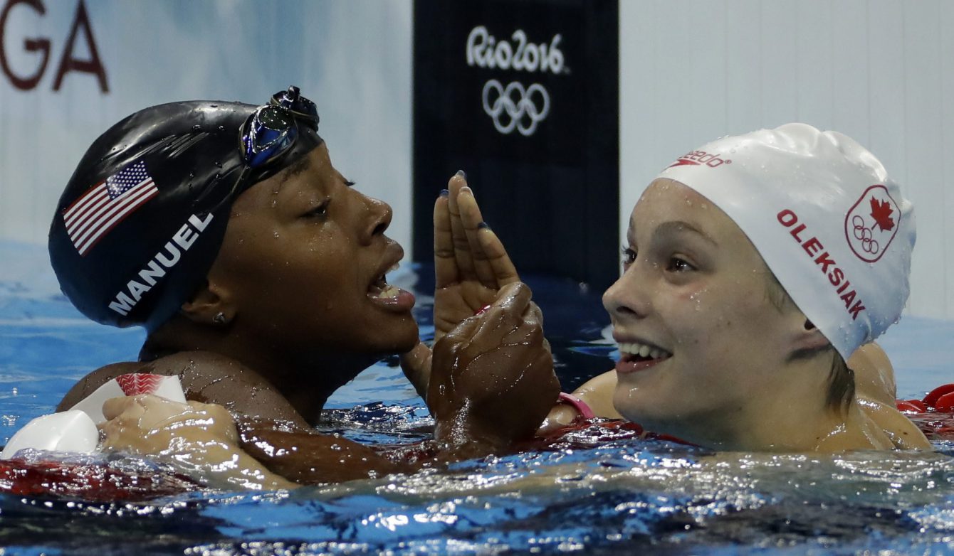 Penny Oleksiak célèbre sa médaile d'or avec l'Américaine Simone Manuel, au 100 m style libre. AP Photo/Martin Meissner