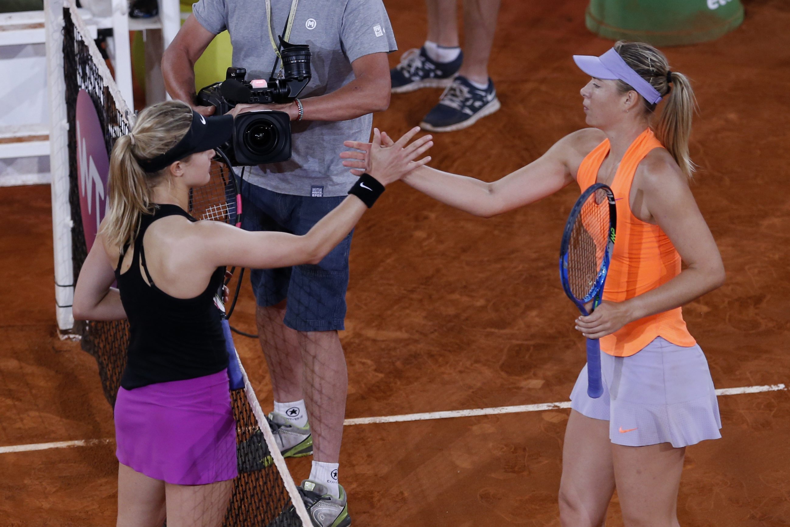 Eugenie Bouchard (gauche) et Maria Sharapova se serrent la main au terme de leur match de deuxième tour au tournoi de la WTA de Madrid, le lundi 8 mai, 2017.