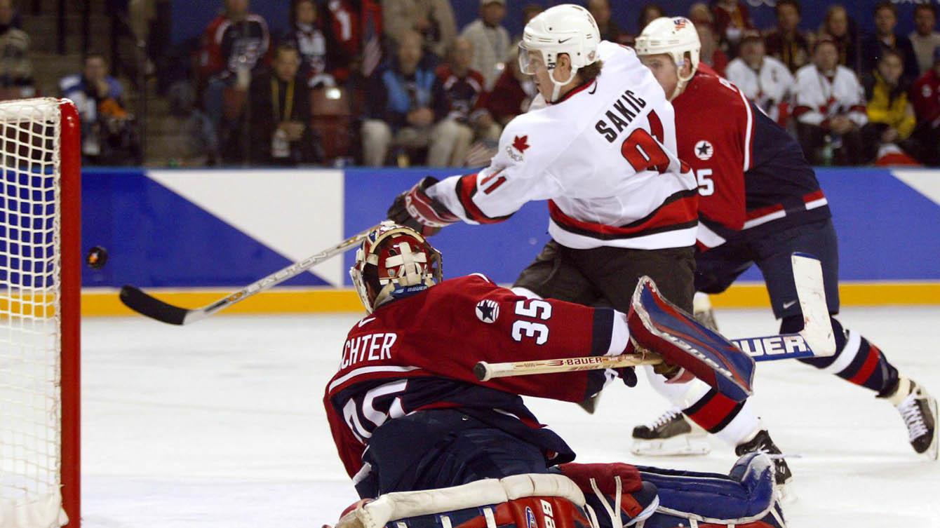 Joe Sakic tente de frapper la rondelle lancée par Jarome Iginla lors du match de la médaille d'or à Salt Lake City en 2002. (PC/Frank Gunn)