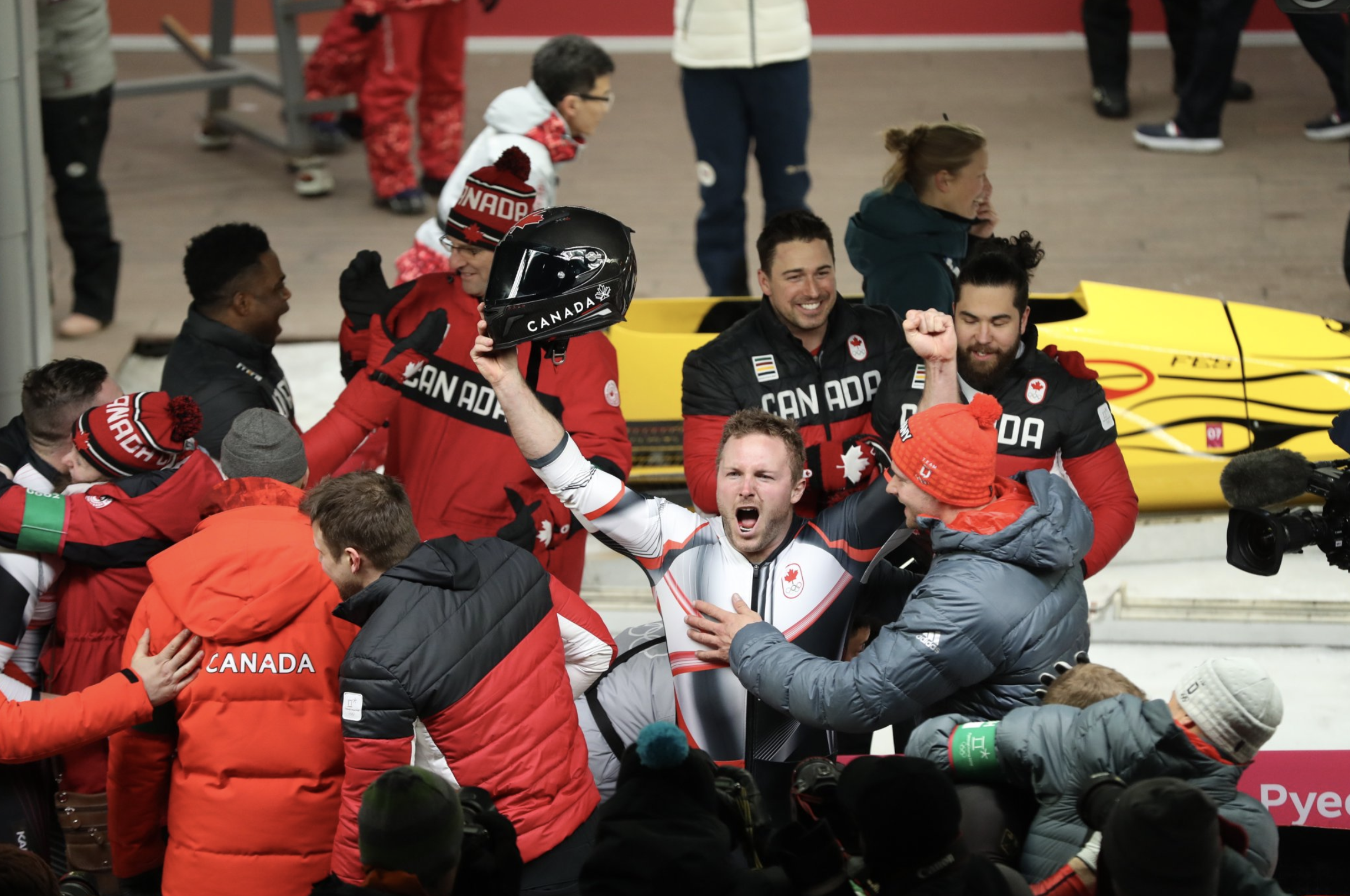 Justin Kripps d'Équipe Canada célèbre en compagnie de ses coéquipiers après avoir remporté la médaille d'or de l'épreuve masculine de bobsleigh à deux aux jeux olympiques de PyeongChang, le 19 février 2018.
