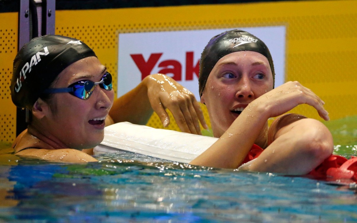 Taylor Ruck, à droite, regarde son temps après la finale féminine du 200 m style libre aux Championnats pan-pacifiques, à Tokyo, le 9 août 2018. AP Photo/Shuji Kajiyama