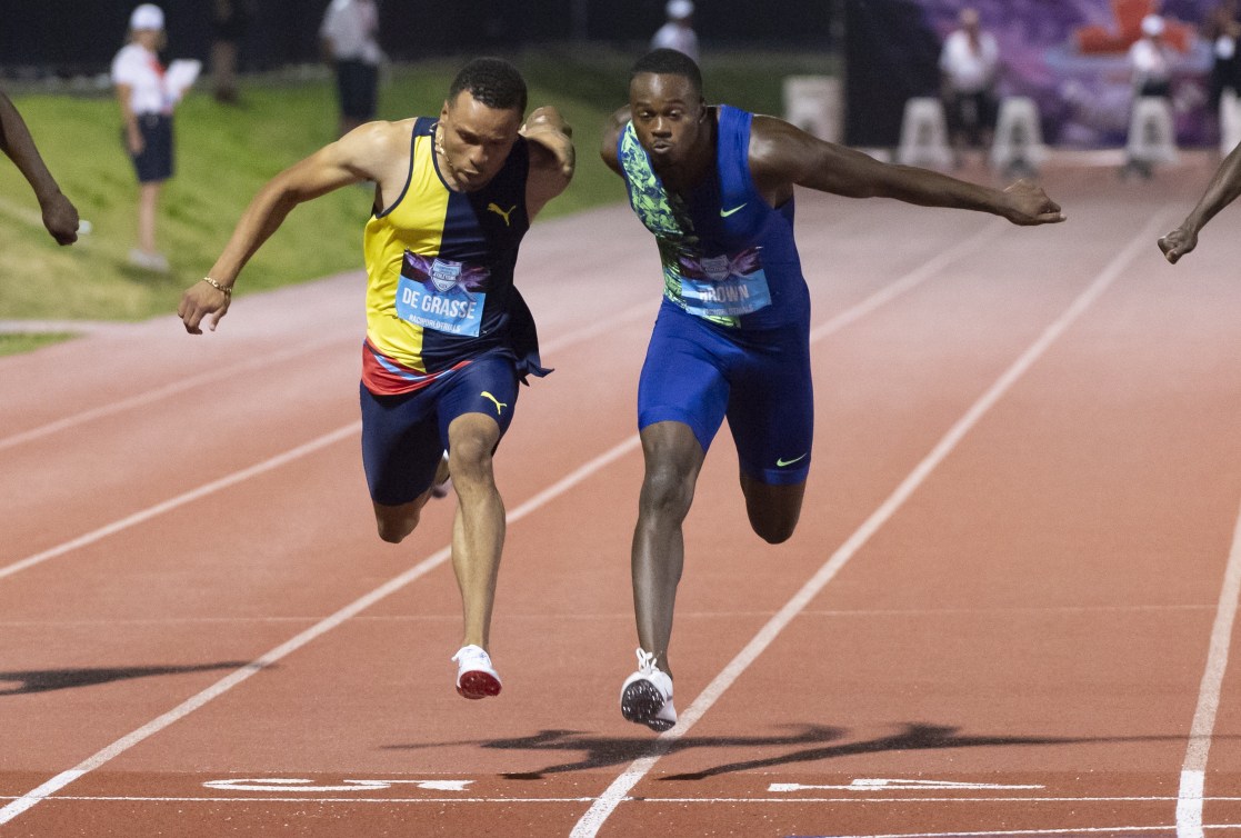 Andre De Grasse et Aaron Brown courent sur une piste d'athlétisme