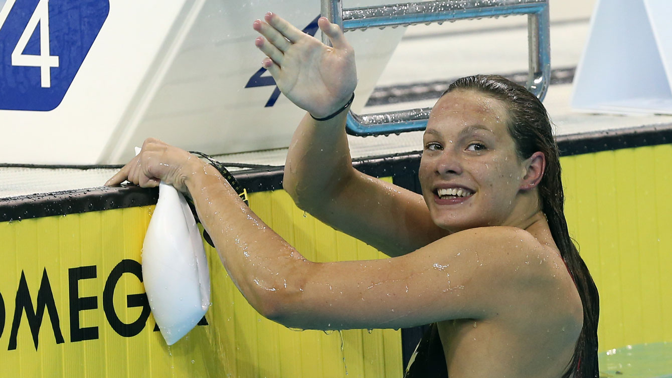 Penny Oleksiak salue la foule de la piscine.